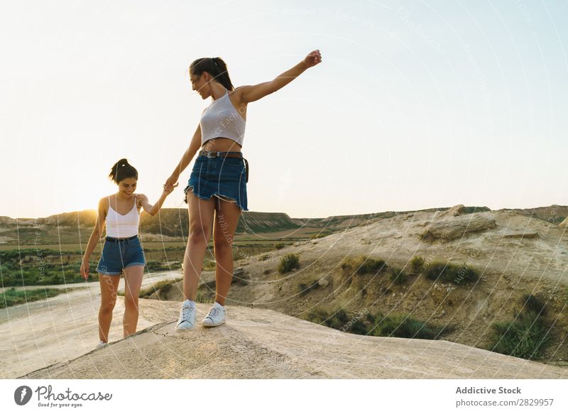 Glückliche Frauen, die auf dem Hügel spazieren gehen. Klippe Aufregung Händchenhalten Freiheit Ferien & Urlaub & Reisen Erfolg Top Berge u. Gebirge Jugendliche