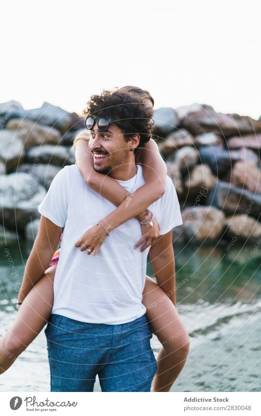 Liebenswertes Paar beim Spielen im Wasser Küste Spaß haben liebevoll Strand tragen Halt Ferien & Urlaub & Reisen auf der Rückseite Sommer Meer Fröhlichkeit