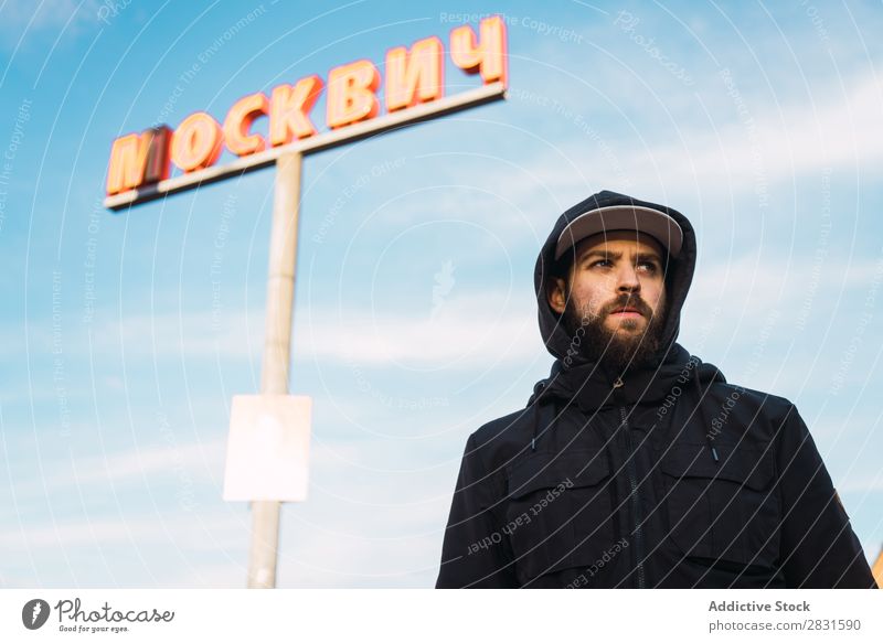 Mann, der auf der Straße an der Säule steht. gutaussehend Großstadt Zeichen Post Wegsehen Jugendliche Stadt Lifestyle lässig Mode Stil Erwachsene modern Mensch