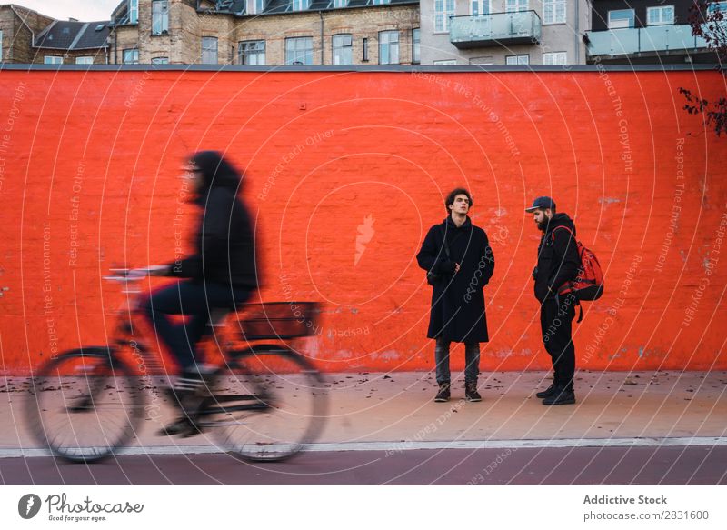 Zwei Männer an der orangefarbenen Wand Mann stehen Orange Zusammensein Straße gutaussehend Großstadt Jugendliche Stadt Lifestyle lässig Mode Stil Erwachsene