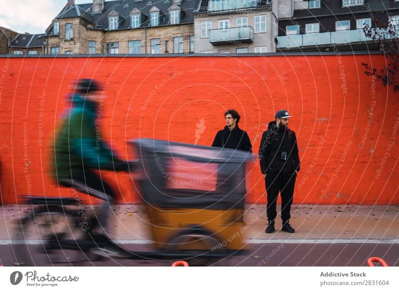 Zwei Männer an der orangefarbenen Wand Mann stehen Orange Zusammensein Straße gutaussehend Großstadt Jugendliche Stadt Lifestyle lässig Mode Stil Erwachsene