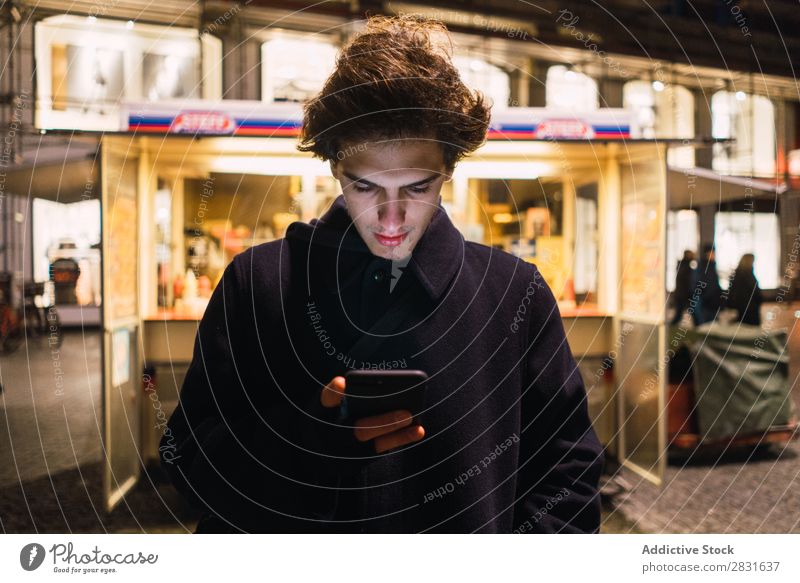 Mann beim Surfen auf dem Smartphone am Abend gutaussehend Großstadt PDA Selfie Schuss Straße Jugendliche Stadt Lifestyle lässig Mode Stil Erwachsene modern