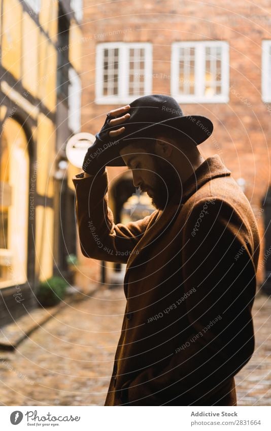 Stilvoller Mann, der sich an die Wand lehnt. gutaussehend Großstadt Mantel Hut anlehnen Straße Jugendliche Stadt Lifestyle lässig Mode Erwachsene modern Mensch