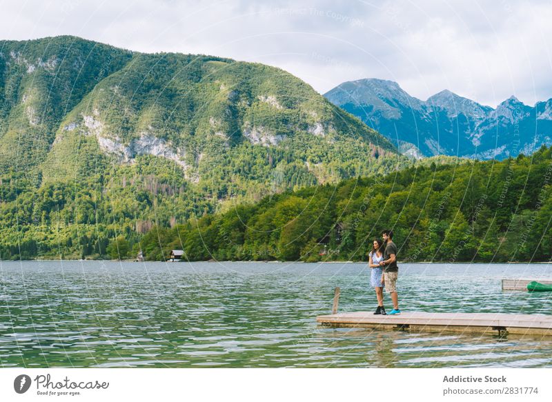 Paar, das auf dem Pier posiert. Anlegestelle Freude See Berge u. Gebirge Glück Liebe Zusammensein Natur Sommer Wasser Jugendliche Frau Ferien & Urlaub & Reisen