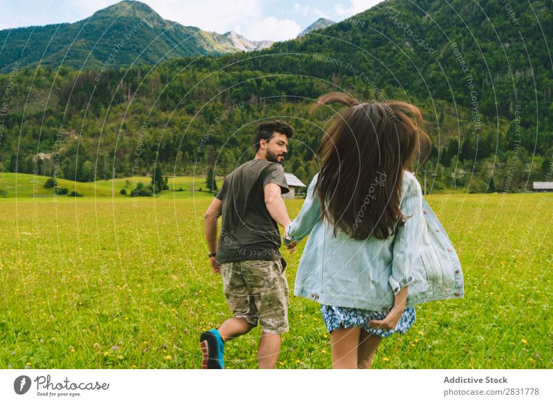 Paar, das auf einer Wiese in Hügeln läuft. Händchenhalten Natur Sommer Mensch Mann Frau Liebe Gras schön Zusammensein Jugendliche Glück Landschaft