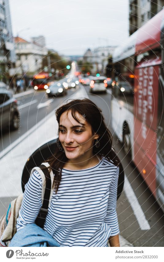 Lächelnde Frau mit urbanem Hintergrund Mensch Großstadt Körperhaltung Zufriedenheit Verkehr Reisender Stadt brünett Außenaufnahme Straße Sommer Model Lifestyle