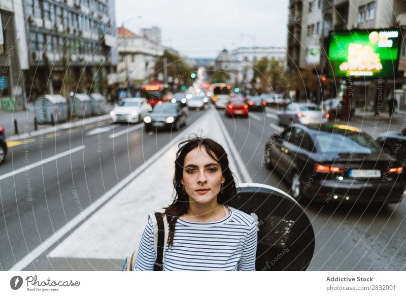 Frau, die auf einer belebten Straße posiert. Mensch Großstadt Körperhaltung Zufriedenheit Menschliches Gesicht Verkehr Reisender emotionslos Stadt brünett