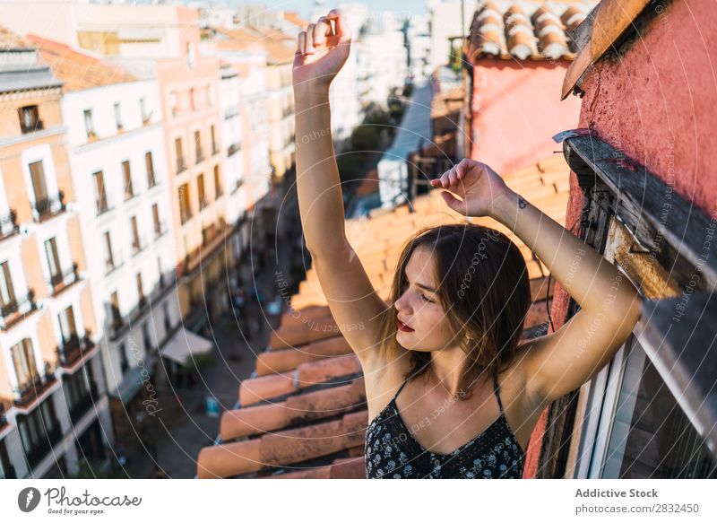 Inhaltsmodell Grimassieren auf dem Balkon Frau heiter romantisch Fröhlichkeit Grimasse Skyline Terrasse Körperhaltung Ausdruck Beautyfotografie Jugendliche