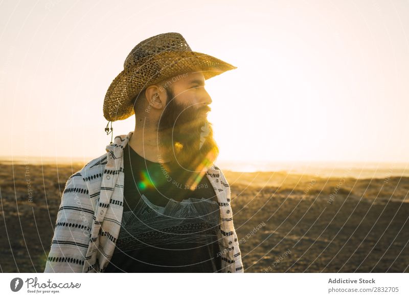 Bartiger Mann mit Hut gegen Sonnenlicht bärtig Cowboy Stil selbstbewußt Natur Porträt Länder maskulin ernst Strohhut Outfit Außenaufnahme Ausdruck Reisender