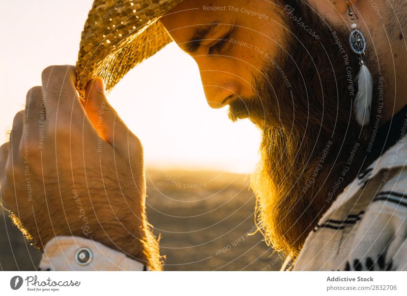 Bartiger Mann mit Hut gegen Sonnenlicht bärtig Cowboy Stil selbstbewußt Natur Porträt Länder maskulin ernst Strohhut Outfit Außenaufnahme Ausdruck Reisender