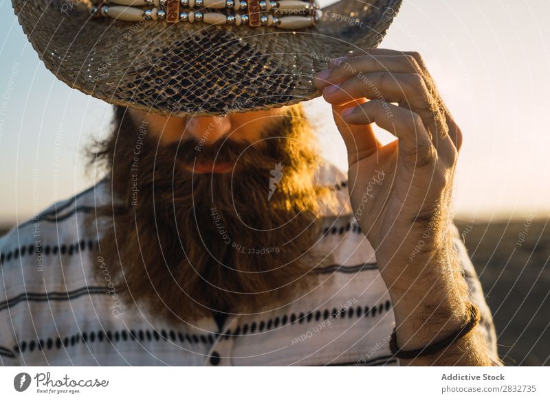 Bartiger Mann mit Hut gegen Sonnenlicht bärtig Cowboy Stil selbstbewußt Natur Porträt Länder maskulin ernst Strohhut Outfit Außenaufnahme Ausdruck Reisender