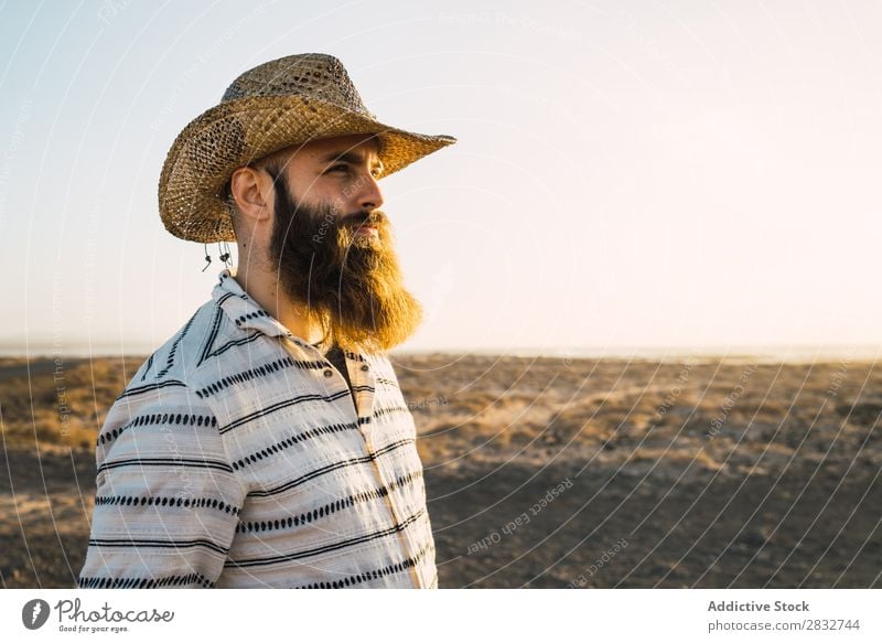 Bartiger Mann mit Hut gegen Sonnenlicht bärtig Cowboy Stil selbstbewußt Natur Porträt Länder maskulin ernst Strohhut Outfit Außenaufnahme Ausdruck Reisender