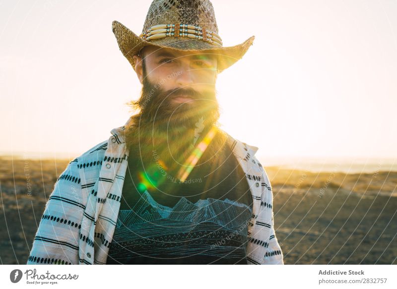 Bartiger Mann mit Hut gegen Sonnenlicht bärtig Cowboy Stil selbstbewußt Natur Porträt Länder maskulin ernst Strohhut Outfit Außenaufnahme Ausdruck Reisender