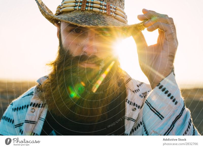 Bartiger Mann mit Hut gegen Sonnenlicht bärtig Cowboy Stil selbstbewußt Natur Porträt Länder maskulin ernst Strohhut Outfit Außenaufnahme Ausdruck Reisender