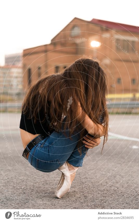 Frau sitzt auf Zehenspitzen Balletttänzer sitzen Tanzen Pose Spielplatz Straße Entwurf Großstadt Stadt Mädchen Tänzer Ballerina elegant schön Leistung hübsch