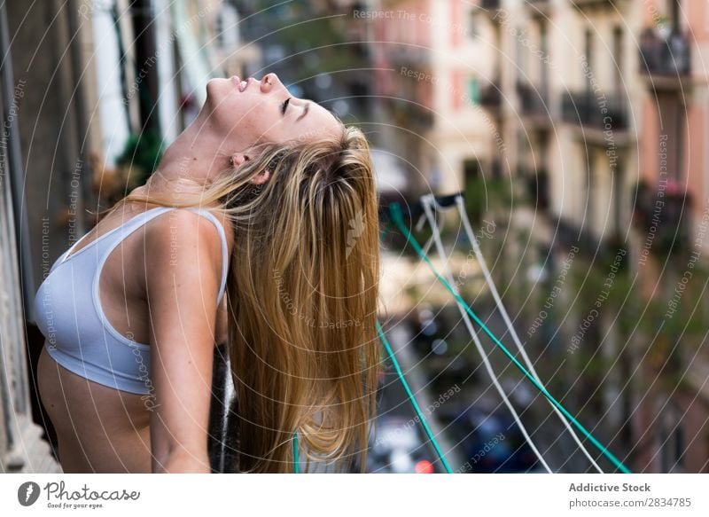 Sexy junge Frau, die auf dem Balkon atmet. Mensch Haus Jugendliche Erotik Mädchen Kaukasier Glück heimwärts hübsch schön heiter Erholung Beautyfotografie weiß