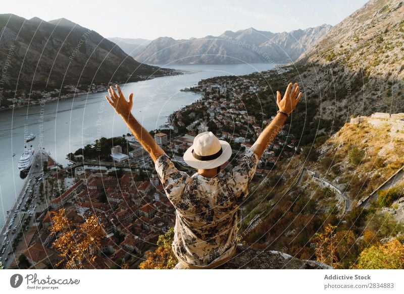 Tourist schaut auf die Stadt am Flussufer. Berge u. Gebirge Mann Mensch Dorf Aussicht Weg Landschaft Ferien & Urlaub & Reisen Hände hoch Natur Tourismus schön