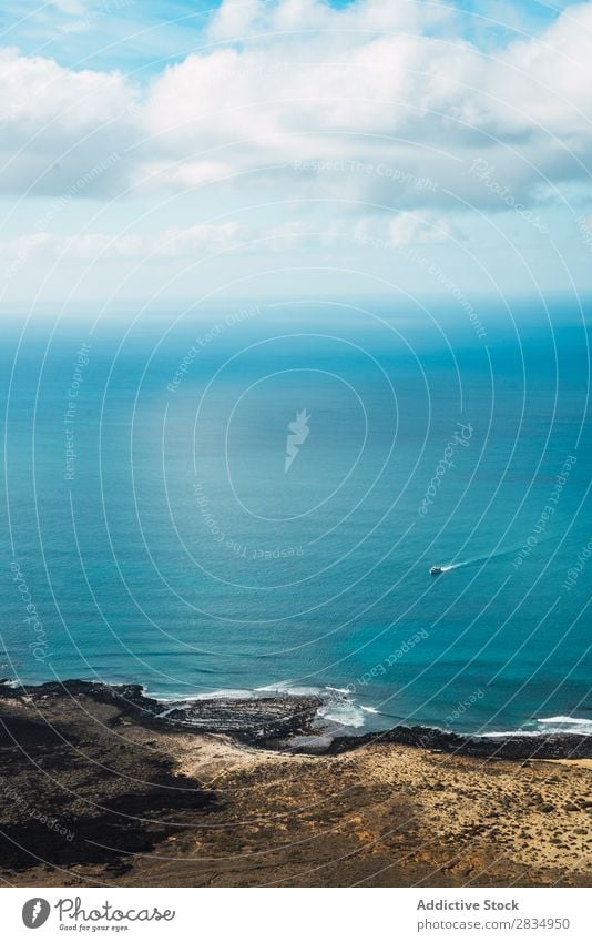 Kleines Boot in blauem Meer Insel Wolken Gefäße klein fliegend Fluggerät Natur Landschaft natürlich Felsen Stein Lanzarote Spanien Aussicht