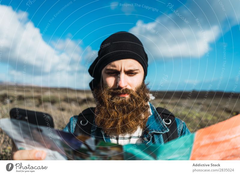 Touristischer Mann mit Karte und Smartphone Feld Landkarte Navigation verirrt Rucksack stehen ruhen Wolken Natur Landschaft natürlich Lanzarote Spanien Aussicht