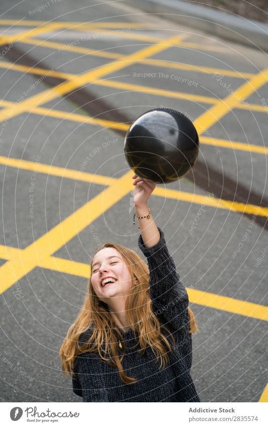 Junges Mädchen in Barcelona Frau hübsch Luftballon schwarz Lachen heiter Mund geöffnet parken Los Linien Boden gelb Porträt jung schön Behaarung Pullover lässig