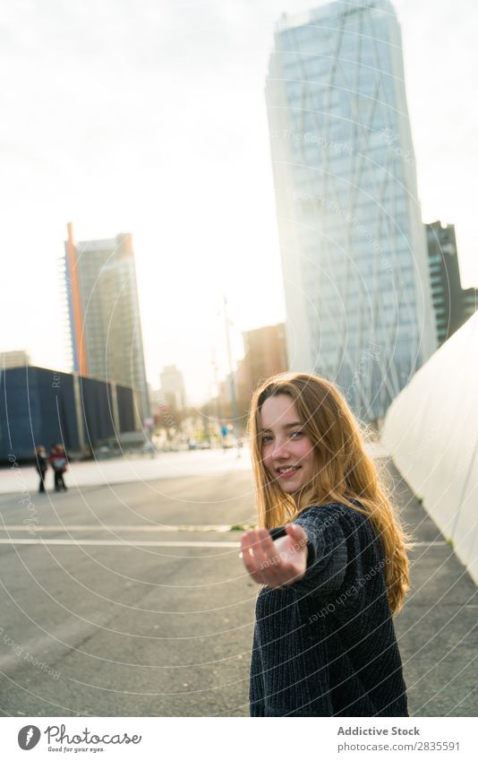 Eine Frau, die gestikuliert, folgt mir. mir folgen gestikulieren Lächeln heiter träumen Gebäude Hand Straße Großstadt Stadt Blick in die Kamera hübsch