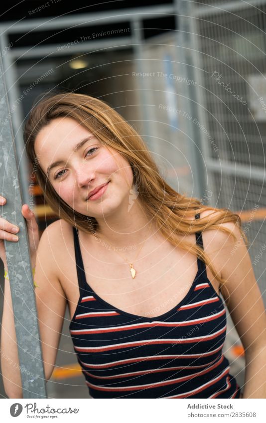 Hübsche junge Frau, die steht und lächelt. Horizontale Außenaufnahme. hübsch Porträt Lachen schön in die Kamera schauen berührend Wange heiter Lächeln Glück