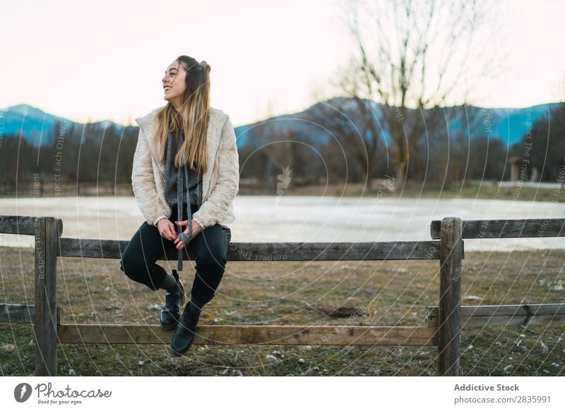 Stylisches junges Mädchen am Zaun auf der Natur Frau Zufriedenheit Landschaft ländlich sitzen heiter Freiheit Unbekümmertheit Kokette Haare & Frisuren