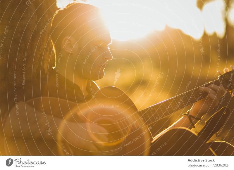 Mann spielt Gitarre in der Natur Musik Wald Sonnenstrahlen Tag anlehnen sitzen Rüssel Lifestyle Musiker lässig Gitarrenspieler akustisch Herbst Musical Mensch