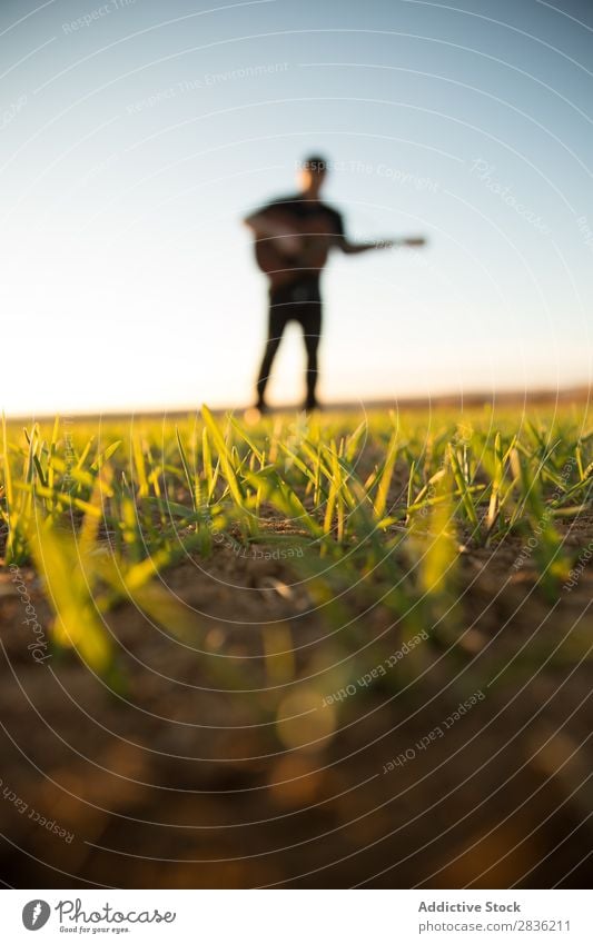 Mann mit Gitarre auf dem Feld Natur Musik stehen Lifestyle Musiker lässig Gitarrenspieler akustisch grün laufen Musical Mensch Typ natürlich Instrument Spielen