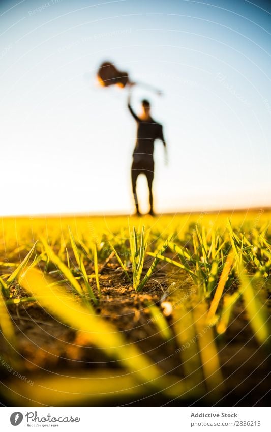 Mann mit Gitarre auf dem Feld Natur Musik stehen Lifestyle Musiker lässig Gitarrenspieler akustisch grün laufen Musical Mensch Typ natürlich Instrument Spielen