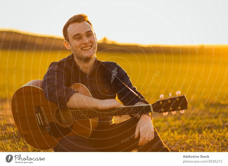 Mann mit Gitarre auf dem Feld Natur Musik Lifestyle Musiker lässig Gitarrenspieler akustisch grün laufen Musical Mensch Typ natürlich Instrument Spielen Stil