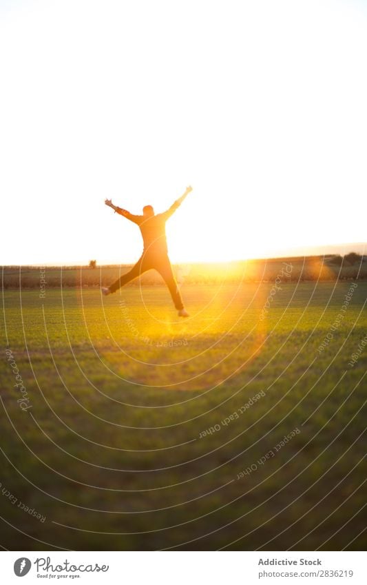 Mann springt auf sonniges Feld Freude springen Fröhlichkeit Sommer Freiheit Natur Aktion Mensch Jugendliche Wiese Gras Energie grün Lifestyle frei rennen