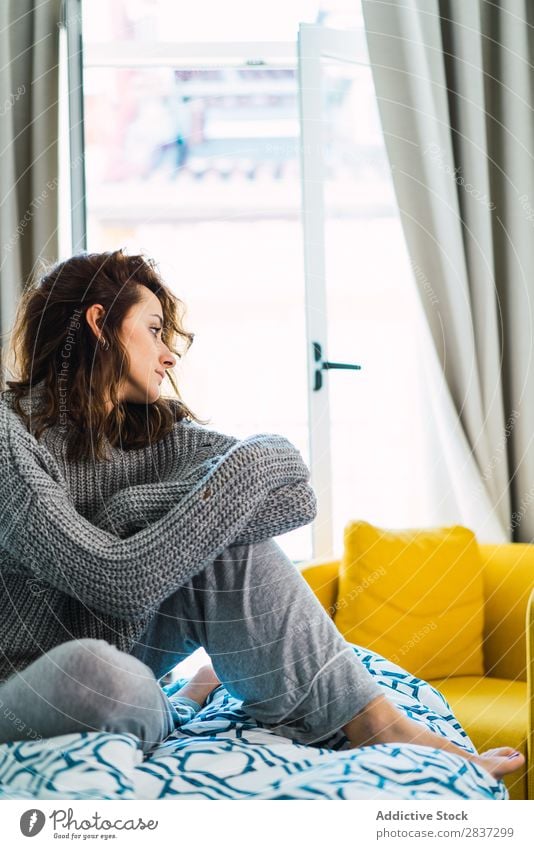 Junge Frau sitzt und ruht sich auf dem Bett aus. heimwärts hübsch träumen sitzen Wegsehen Jugendliche Körperhaltung Erholung Porträt schön Lifestyle