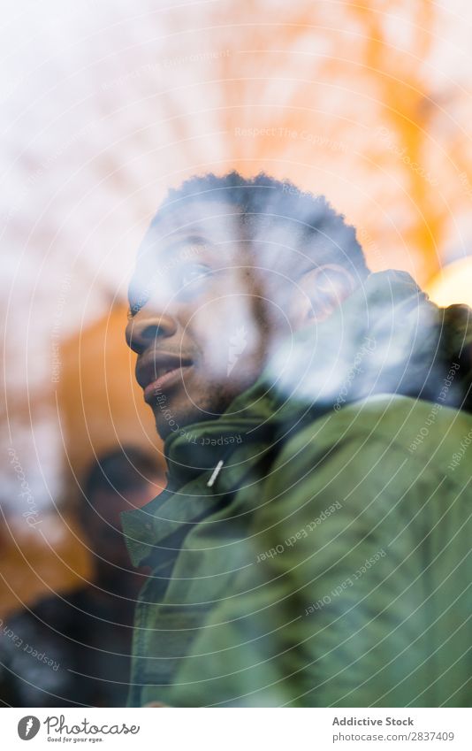 Schwarzer Mann schaut auf die Straße Großstadt Stil Jugendliche Stadt Lifestyle lässig Schickimicki Mode Erwachsene sportlich schwarz durch das Fenster