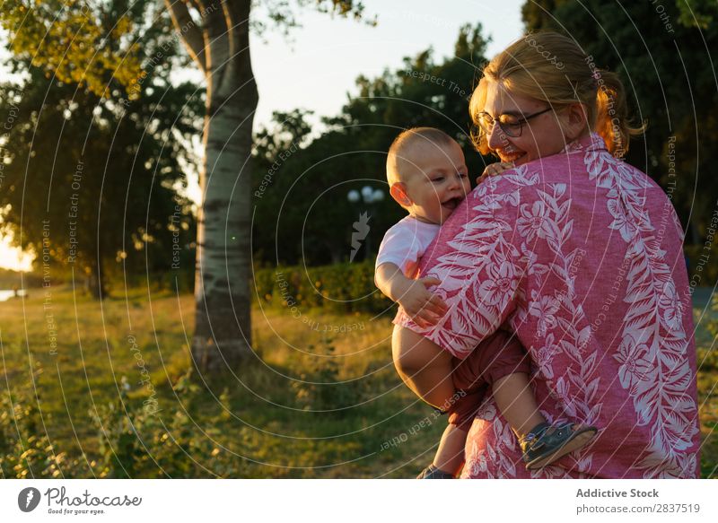 Mutter hält das Kind an den Händen im Park. Sonnenstrahlen auf Händen Familie & Verwandtschaft Glück Mensch Frau Fröhlichkeit Sommer Lifestyle Liebe Eltern