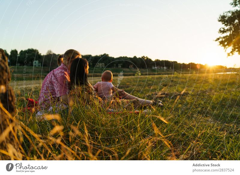 Glückliche lesbische Familie mit Kind Mutter Park Rasen grün Sonnenstrahlen Mensch Frau Fröhlichkeit Sommer Lifestyle Liebe gleichgeschlechtliche Eltern