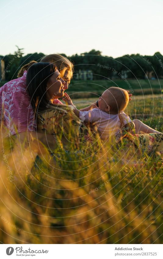 Glückliche lesbische Familie mit Kind Mutter Park Rasen grün Sonnenstrahlen Mensch Frau Fröhlichkeit Sommer Lifestyle Liebe gleichgeschlechtliche Eltern