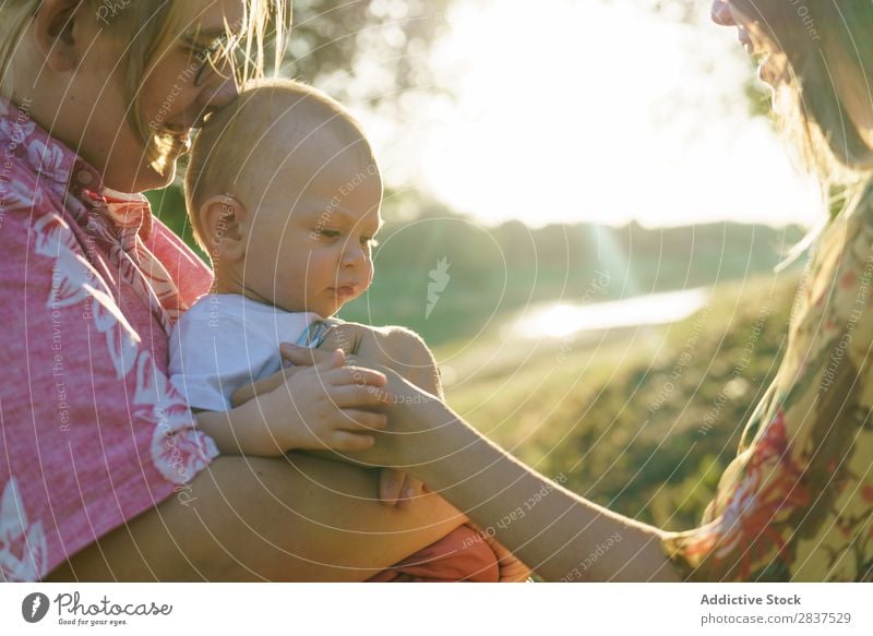 Glückliches lesbisches Paar mit Kind Mutter Park grün Sonnenstrahlen Mensch Frau Fröhlichkeit Sommer Lifestyle Liebe gleichgeschlechtliche Eltern Homosexualität