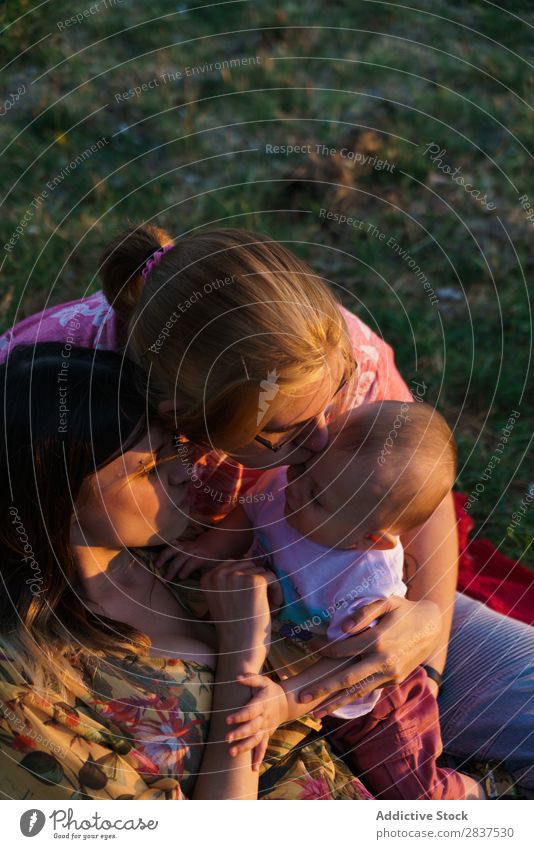 Glückliche lesbische Familie mit Kind Mutter Park Rasen grün Sonnenstrahlen Mensch Frau Fröhlichkeit Sommer Lifestyle Liebe gleichgeschlechtliche Eltern