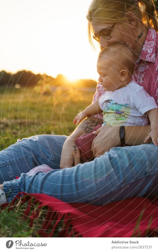 Frau mit Kind auf dem Rasen Mutter Park grün Sonnenstrahlen Glück Mensch Fröhlichkeit Sommer Lifestyle Liebe gleichgeschlechtliche Eltern Homosexualität Paar