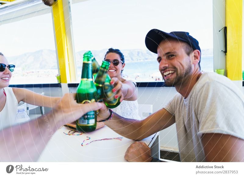 Junge Freunde, die mit Bier klirren. Mensch Freundschaft Party Feste & Feiern Zuprosten Gratulation Café Sammeln klirrend Ferien & Urlaub & Reisen heiter