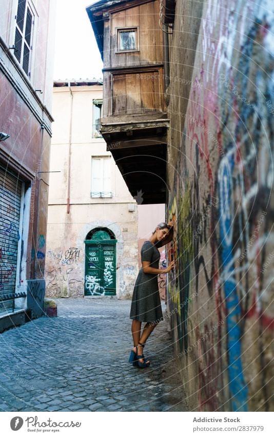 Lächelnde Frau in der Gasse Graffiti Wand hübsch Straße Lifestyle heiter ruhig Erholung blond laufen lieblich attraktiv Dame Großstadt Jugendliche Mensch