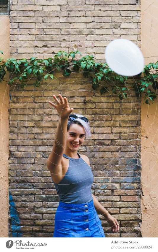 Charmante Frau posierend mit Ballon Körperhaltung Luftballon Straße lässig Sommer Gefühle Fröhlichkeit feminin Backsteinwand Zufriedenheit charmant Ausdruck