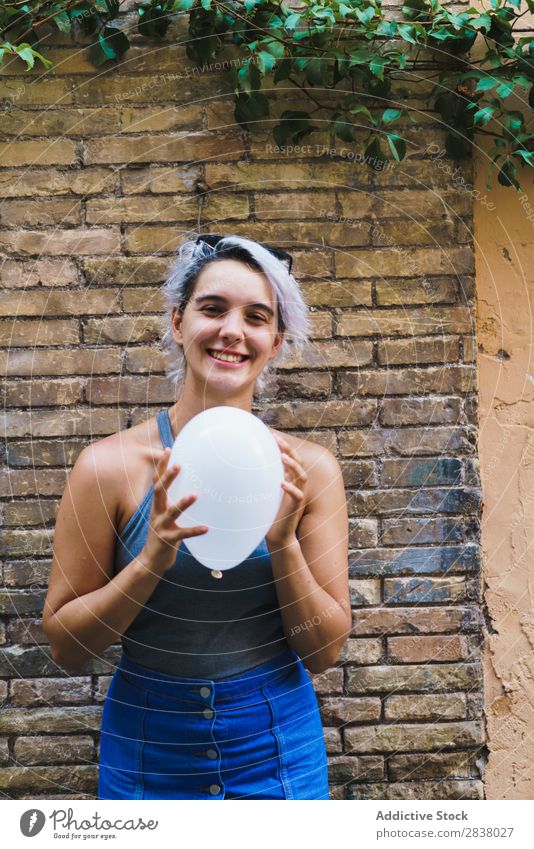 Charmante Frau posierend mit Ballon Körperhaltung Luftballon Straße lässig Sommer Gefühle Fröhlichkeit feminin Backsteinwand Zufriedenheit charmant Ausdruck