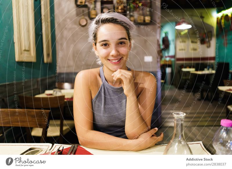 Junge Frau, die in einer Bar posiert. Körperhaltung Feste & Feiern lässig trinken Erholung Innenarchitektur Pub Beautyfotografie Getränk Glas horizontal