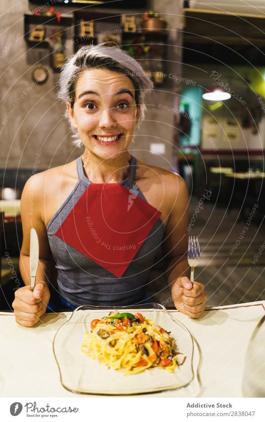 Zufriedene Frau beim Essen Teller Fröhlichkeit Gefühle Lebensmittel Feinschmecker Grimasse Abendessen Spaß haben lässig Halt Mittagessen so tun, als ob