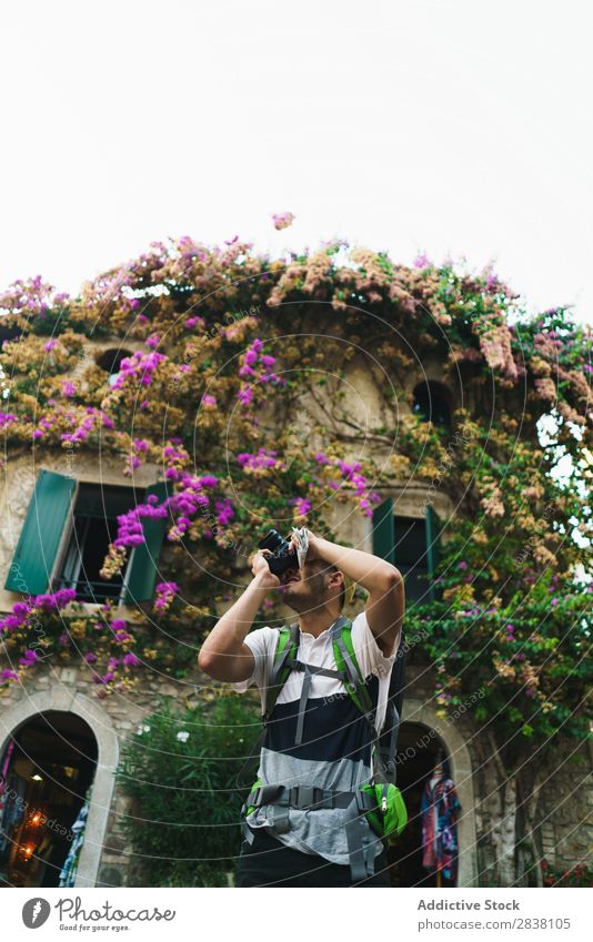 Mann fotografiert Umgebung in der Stadt Backpacker Tourist fotografierend Erinnerung romantisch Fotograf Fotokamera Straße reisend Großstadt Lifestyle