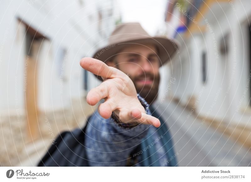 Fröhlicher bärtiger Mann, der auf die Kamera schaut und mir mit Gesten folgt. Tourist mir folgen gestikulieren Blick in die Kamera gutaussehend Lächeln Hand