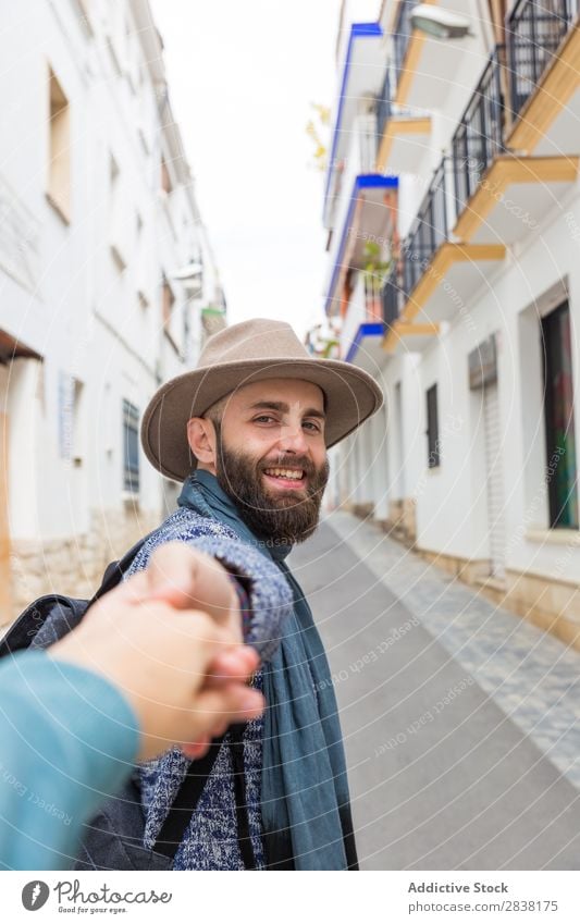 Mann hält die Hand des Fotografen. Tourist mir folgen gestikulieren Blick in die Kamera bärtig gutaussehend Lächeln gestikulierend Ferien & Urlaub & Reisen