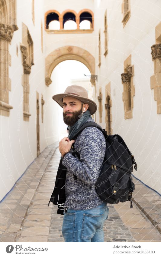 Tourist blickt zurück auf die Gasse Rucksack Straße Blick nach hinten Kopfhörer Hut bärtig gutaussehend Ausflug Ferien & Urlaub & Reisen Großstadt Jugendliche